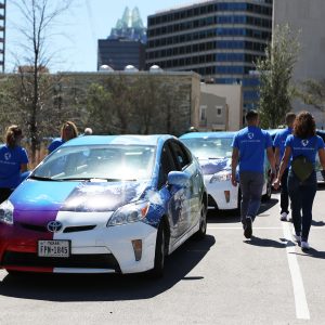 Cool Effect hired a fleet of Priuses and a team of young "brand ambassadors" to shuttle concertgoers people around Austin and engage them in discussions carbon offsetting. The shirts say, "Earth, We're Here."